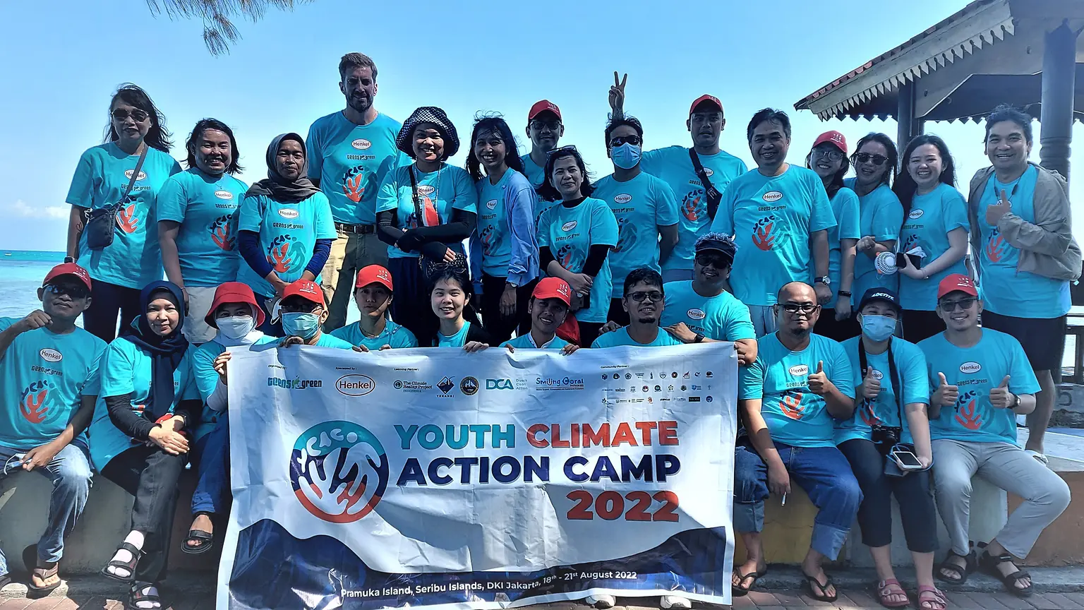 Group photo of participants and organizers wearing blue shirts.